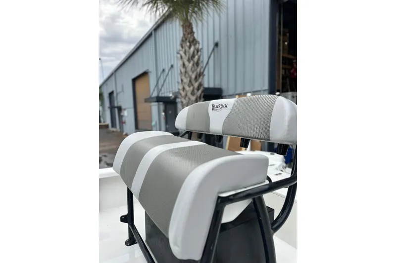 Slide: The Image of 2018 BlackJack 224 boat seat with gray and white upholstery, outdoor setting. - 16