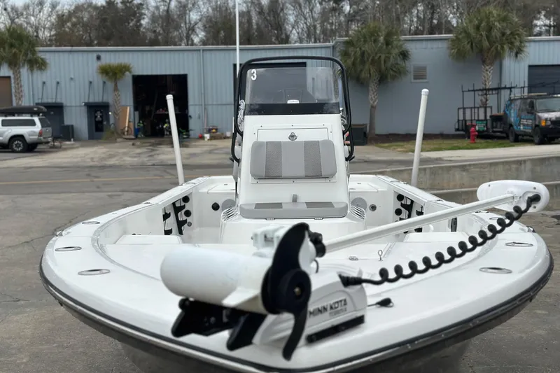 Slide: The Image of 2018 BlackJack 224 boat with Minn Kota trolling motor, parked near industrial buildings. - 9