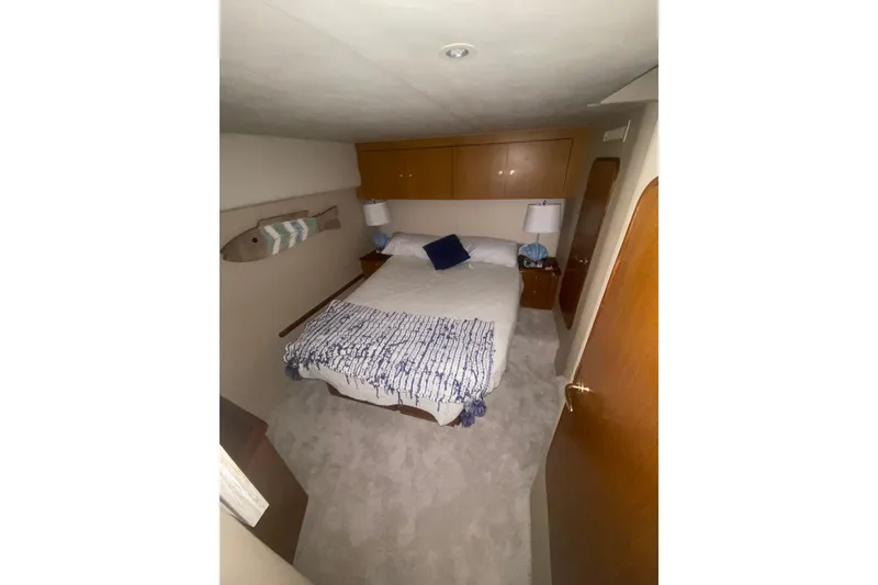 Slide: The Image of Cozy bedroom in 2002 Ocean Yacht Super Sport with nautical decor and wooden cabinetry. - 2