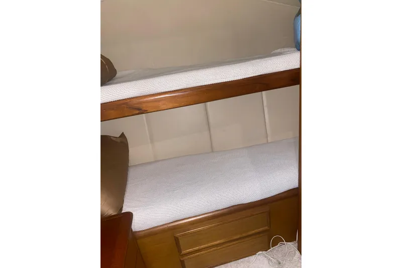 Slide: The Image of Bunk beds in 2002 Ocean Yacht Super Sport cabin, featuring wooden frames and white bedding. - 9