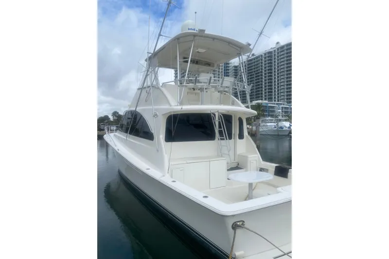 The Image of 2002 Ocean Yacht Super Sport docked at marina, featuring spacious deck and flybridge. - 1