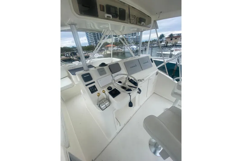 Slide: The Image of 2002 Ocean Yacht Super Sport helm with navigation equipment and marina view. - 11