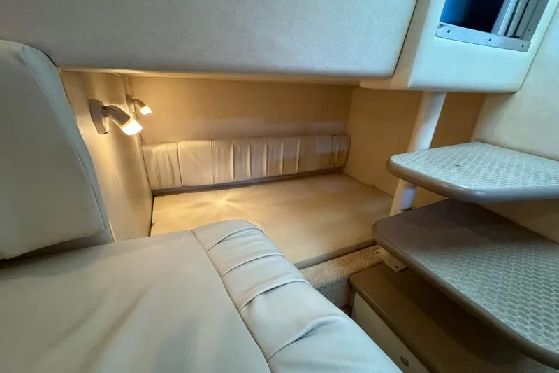 Slide: The Image of 2003 Sea Ray 290 Amberjack cabin interior with cozy seating and soft lighting. - 15