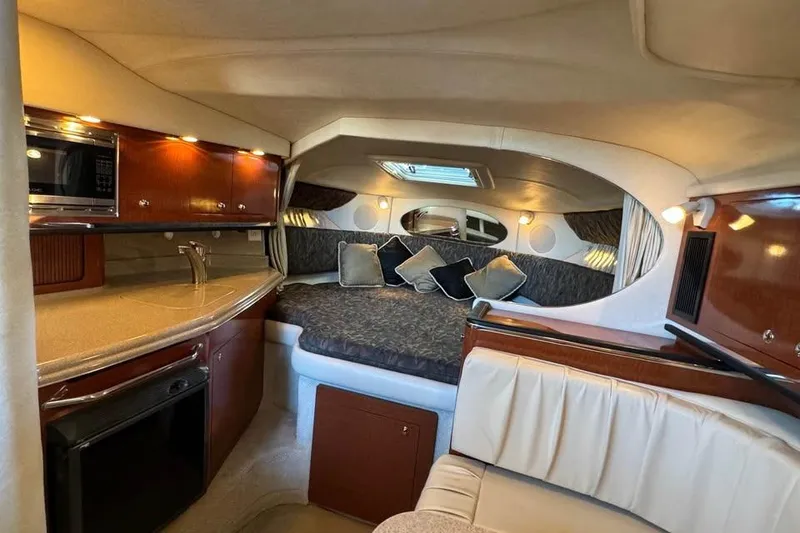 Slide: The Image of 2003 Sea Ray 290 Amberjack cabin interior with kitchenette and cozy sleeping area. - 16