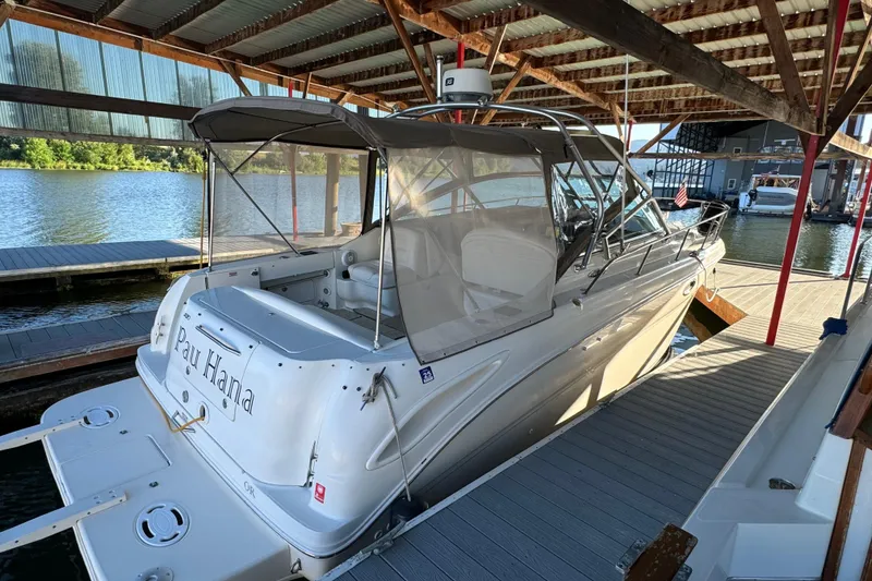 Slide: The Image of 2003 Sea Ray 290 Amberjack docked under a covered marina, rear view. - 7