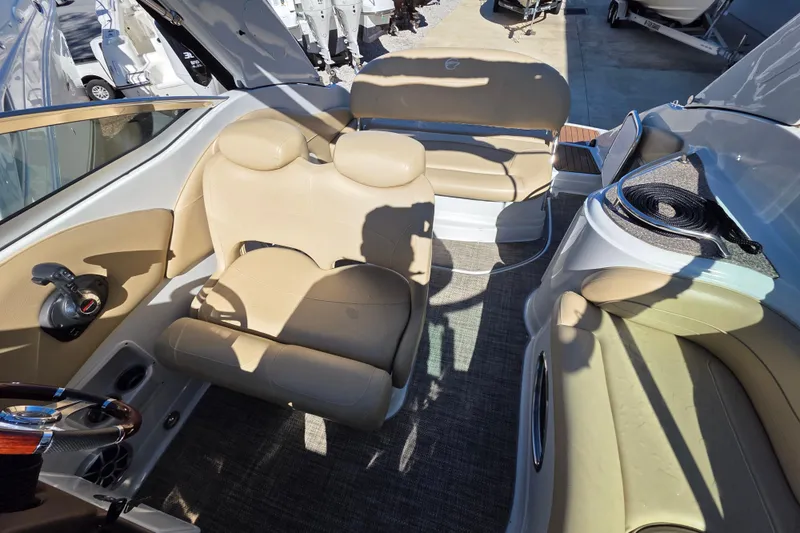Slide: The Image of Interior of 2022 Crownline 264 CR boat with beige seating and steering wheel. - 12