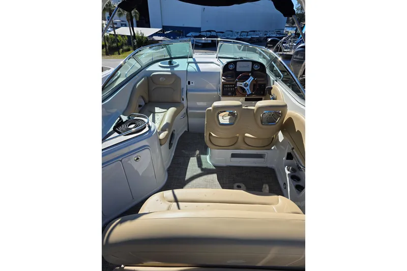 Slide: The Image of Interior view of 2022 Crownline 264 CR boat with beige seating and modern dashboard. - 15