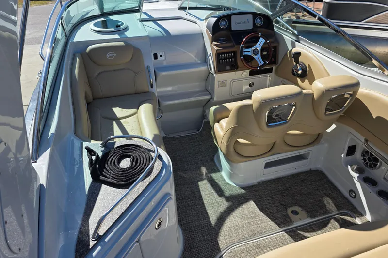 Slide: The Image of 2022 Crownline 264 CR boat interior with beige seating and modern dashboard. - 6