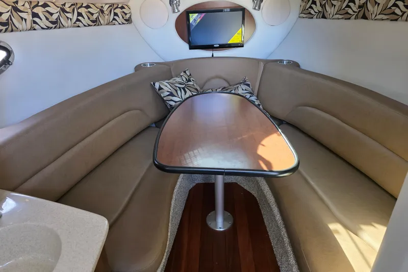 Slide: The Image of 2022 Crownline 264 CR cabin interior with cozy seating and table. - 9