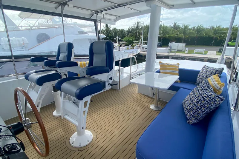 Slide: The Image of 1994 Lyman-Morse Cruising Yacht interior with blue seating, helm chairs, and wooden deck. - 12