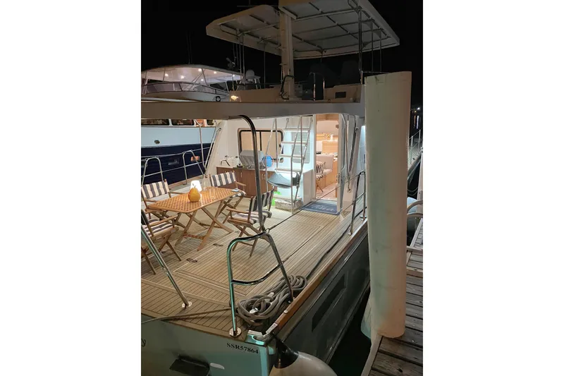 Slide: The Image of 1994 Lyman-Morse Cruising Yacht with illuminated deck and seating area at night. - 18