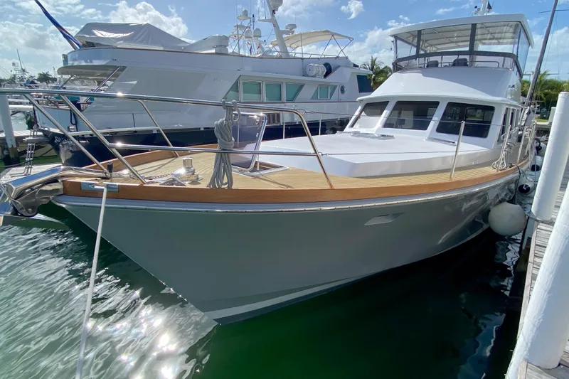 Slide: The Image of 1994 Lyman-Morse Cruising Yacht docked, featuring sleek design and polished wood deck. - 19