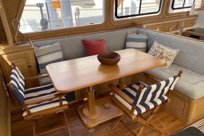 Slide: The Image of Cozy interior of 1994 Lyman-Morse Cruising Yacht with dining area and striped chairs. - 3