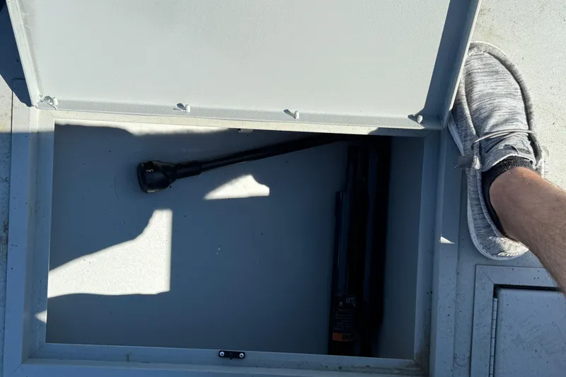 Slide: The Image of Open storage compartment on 2025 Crestliner 1660 Retriever FCC boat with flashlight inside. - 8
