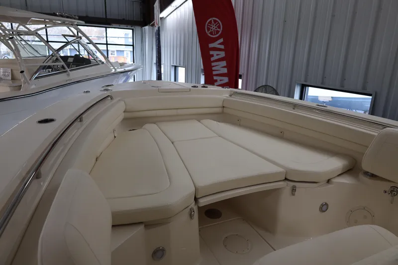 Slide: The Image of 2026 Grady-White Canyon 306 boat interior with cushioned seating in showroom. - 10