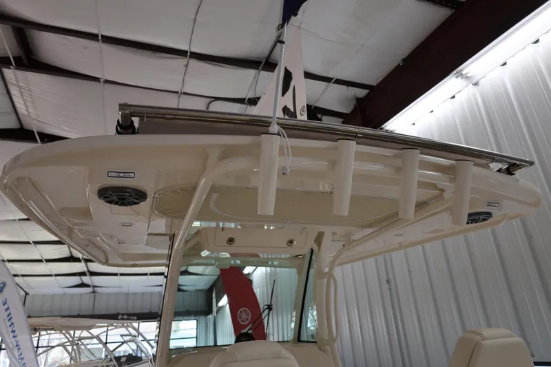 Slide: The Image of 2026 Grady-White Canyon 306 boat interior with rod holders and speakers in a showroom. - 6
