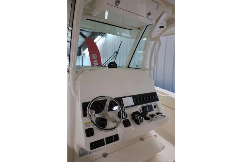 Slide: The Image of 2026 Grady-White Canyon 306 boat dashboard with steering wheel and controls. - 8