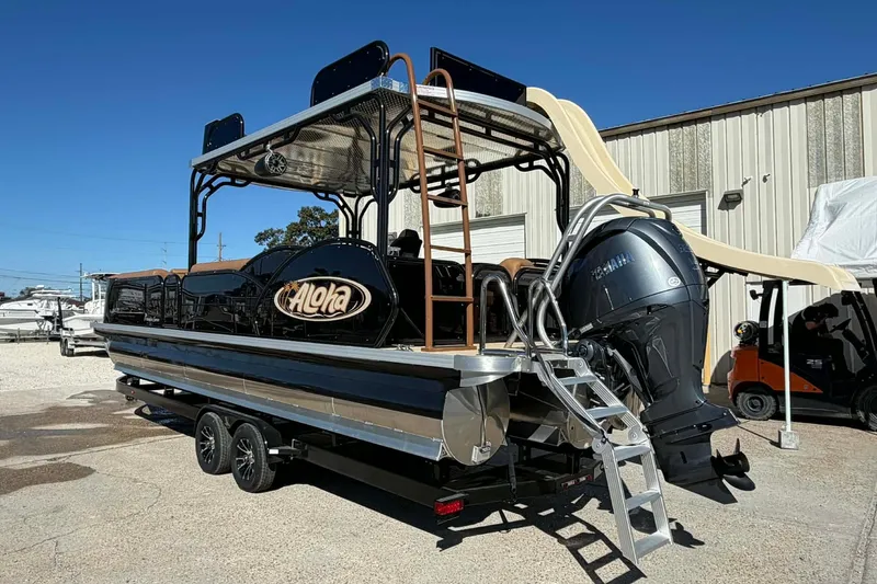 Slide: The Image of 2026 Aloha Paradise 300 Sundeck boat with slide and Yamaha motor in a marina setting. - 2