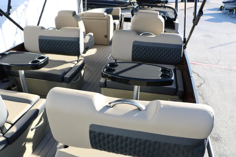 Slide: The Image of 2026 Sylvan L3 RLZ boat interior with beige seating and black tables. - 21