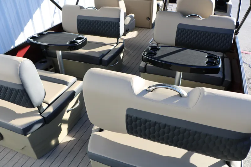 Slide: The Image of 2026 Sylvan L3 RLZ boat interior with beige seating and black tables. - 22