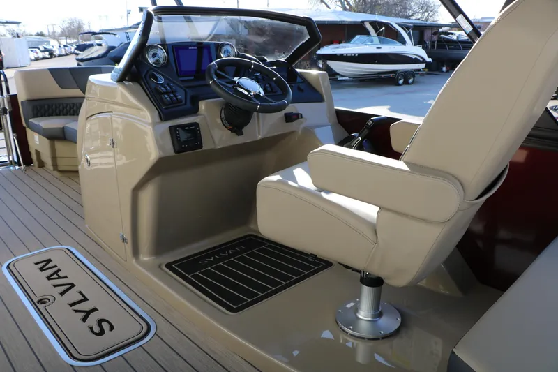 Slide: The Image of 2026 Sylvan L3 RLZ boat interior with steering console and beige seating. - 32