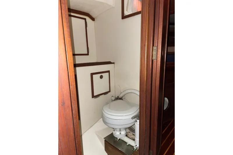 Slide: The Image of 1981 Cape Dory 33 sailboat bathroom with wooden door and compact toilet. - 11