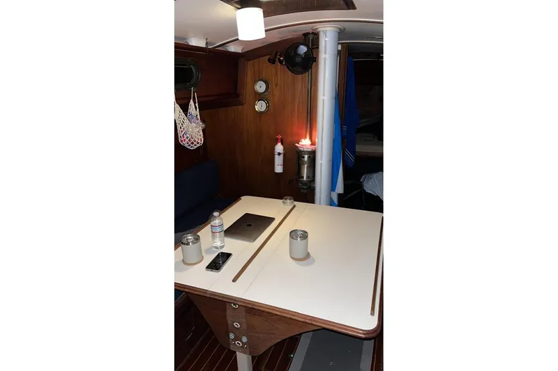 Slide: The Image of Cozy interior of 1981 Cape Dory 33 sailboat with table, fan, and nautical decor. - 12