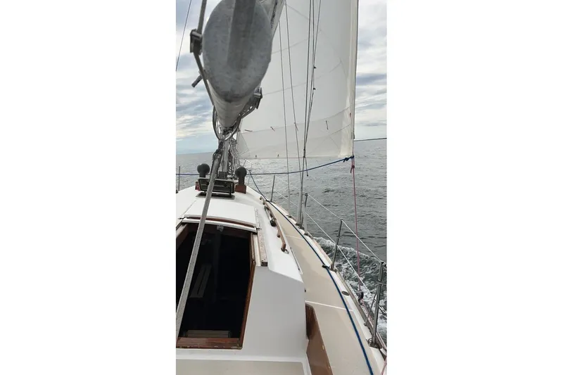 Slide: The Image of Sailing on a 1981 Cape Dory 33 yacht with white sails on open water. - 2