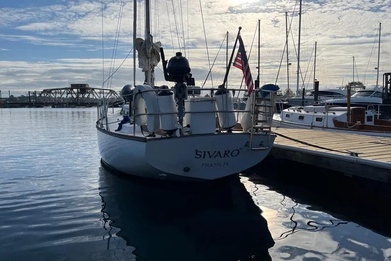 Slide: The Image of 1981 Cape Dory 33 sailboat docked at marina, displaying American flag. - 4