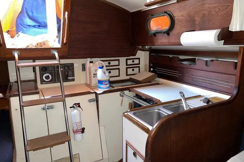 Slide: The Image of 1981 Cape Dory 33 yacht interior with wooden cabinetry, sink, and ladder. - 5