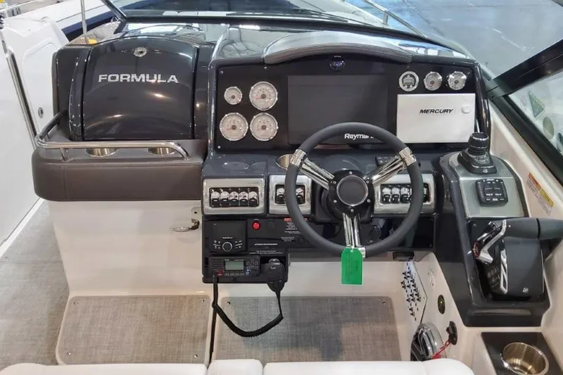 Slide: The Image of 2023 Formula 350 Crossover Bowrider I/O dashboard with steering wheel and control panel. - 32