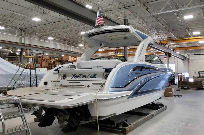 Slide: The Image of 2023 Formula 350 Crossover Bowrider I/O in a warehouse, rear view with American flag. - 7