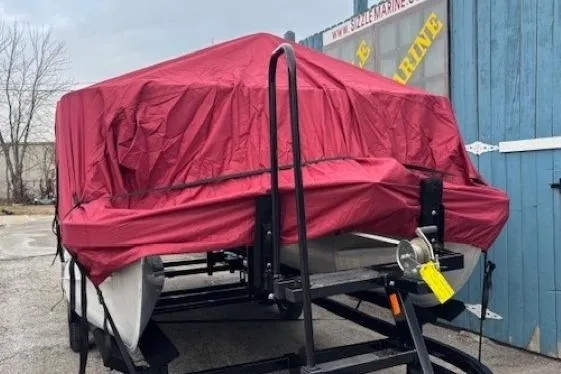 Slide: The Image of 2019 Bennington S 20 SFNP pontoon boat covered with red tarp on trailer. - 29