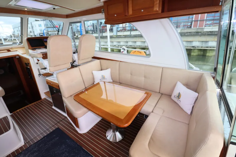 Slide: The Image of Interior of 2019 Back Cove 41 yacht with beige seating and wooden table. - 10