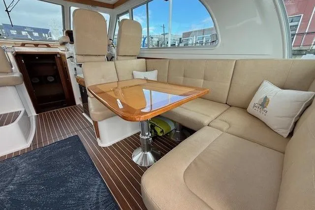 Slide: The Image of Interior of 2019 Back Cove 41 yacht with beige seating and wooden table. - 12