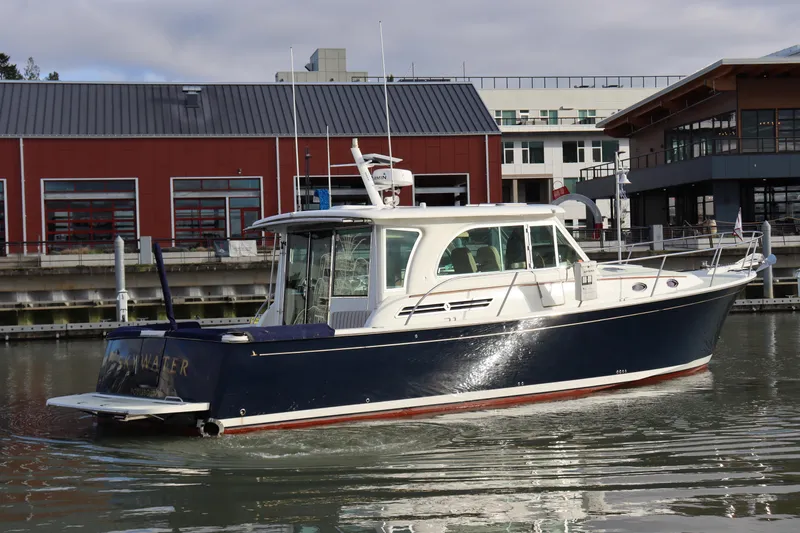 Slide: The Image of 2019 Back Cove 41 boat docked in a marina, featuring a sleek navy and white design. - 5
