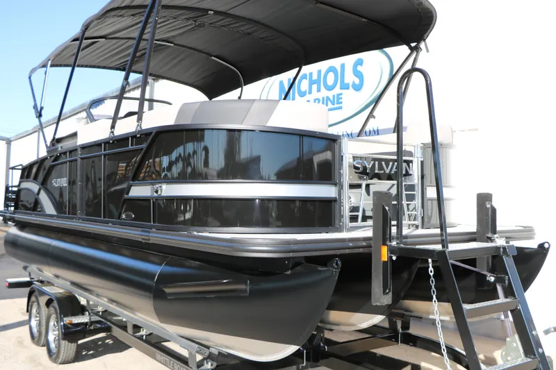 Slide: The Image of 2026 Sylvan L3 CLZ DH pontoon boat with black exterior and canopy on trailer. - 3