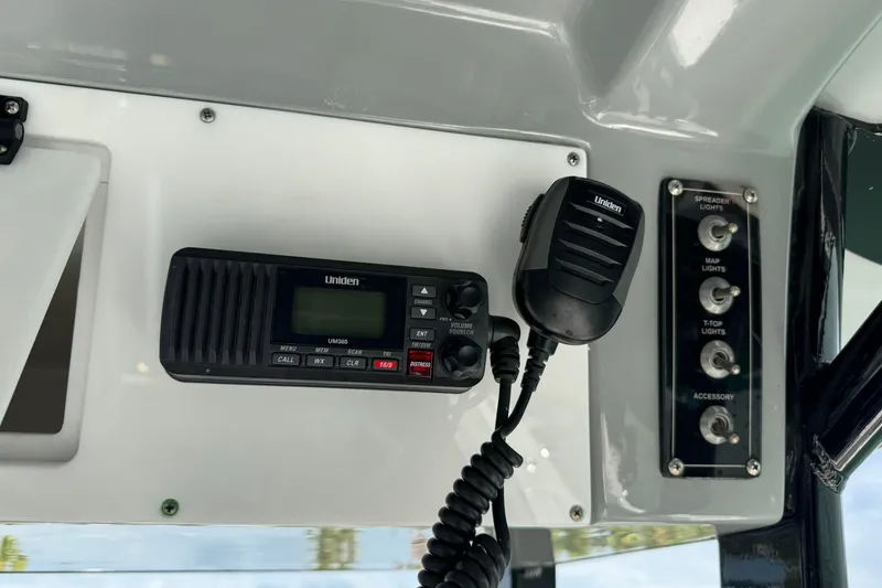 Slide: The Image of 2023 Sea Pro 239 Deep V CC boat console with Uniden radio and light switches. - 16