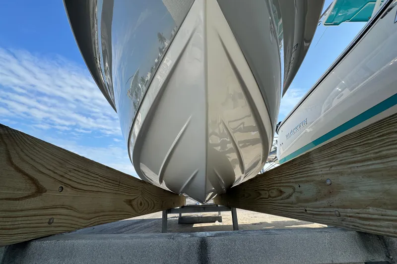 Slide: The Image of 2023 Sea Pro 239 Deep V CC boat hull on wooden support, under clear blue sky. - 39