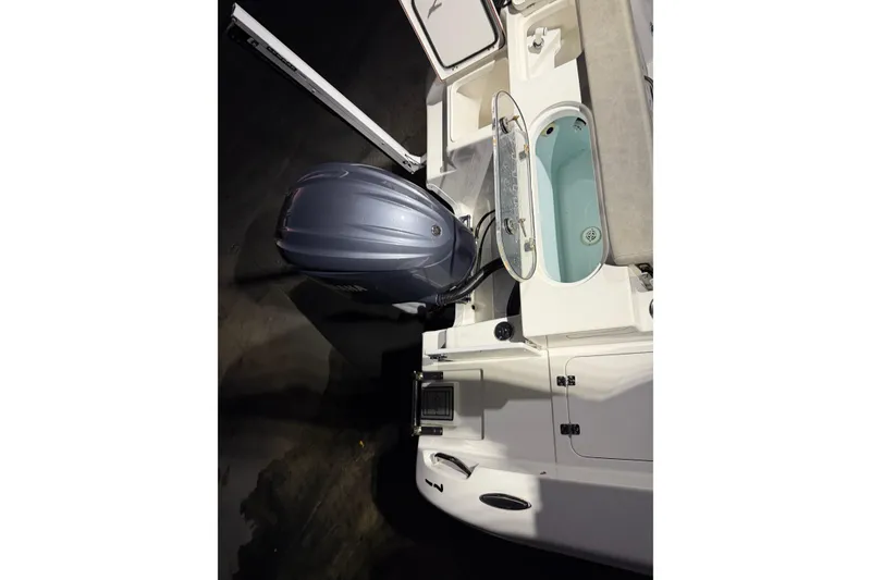 Slide: The Image of 2023 Sea Pro 239 Deep V CC boat with outboard motor and open storage compartments. - 48