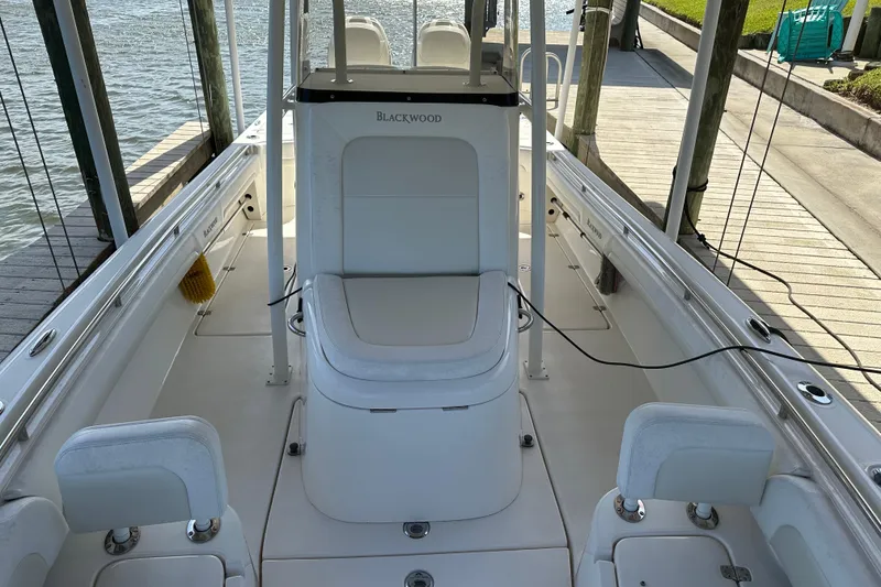 Slide: The Image of 2018 Blackwood 27 Bayboat interior with helm, seating, and storage compartments. - 11