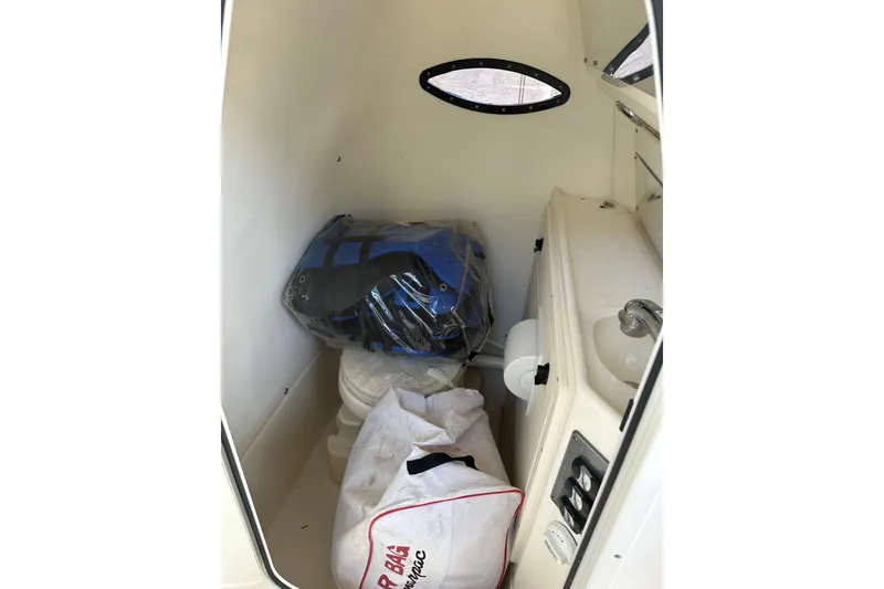 Slide: The Image of 2018 Blackwood 27 Bayboat T-top with rod holders and speakers against a cloudy sky. - 16