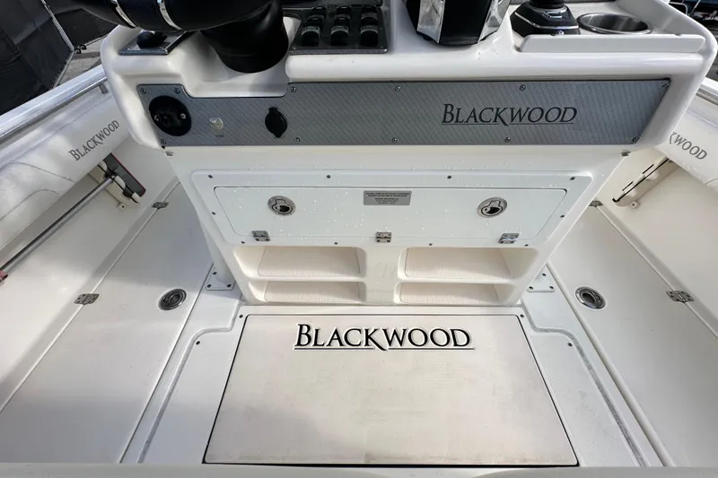 Slide: The Image of 2018 Blackwood 27 Bayboat interior, featuring helm controls and storage compartments. - 17