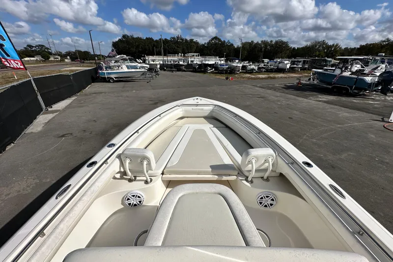 Slide: The Image of 2018 Blackwood 27 Bayboat interior with seating and control panel, docked under a cloudy sky. - 44