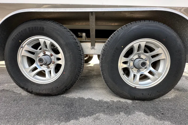 Slide: The Image of Trailer wheels of a 2018 Blackwood 27 Bayboat on asphalt surface. - 95