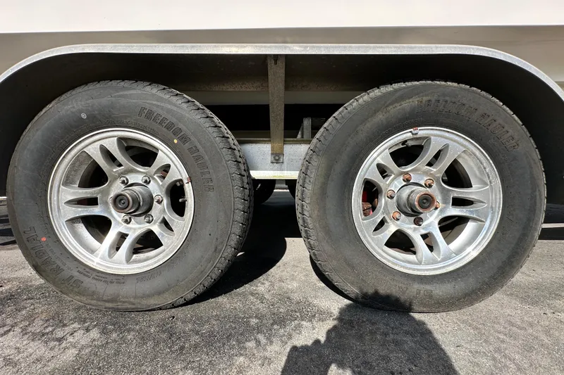 Slide: The Image of Trailer wheels of a 2018 Blackwood 27 Bayboat on pavement. - 96