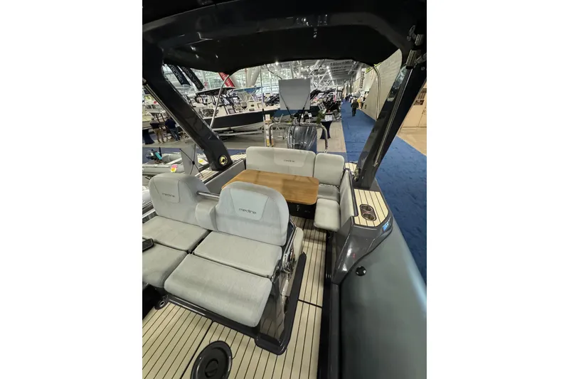 Slide: The Image of 2026 Zodiac Medline 7.5 boat interior with seating and table at a boat show. - 3