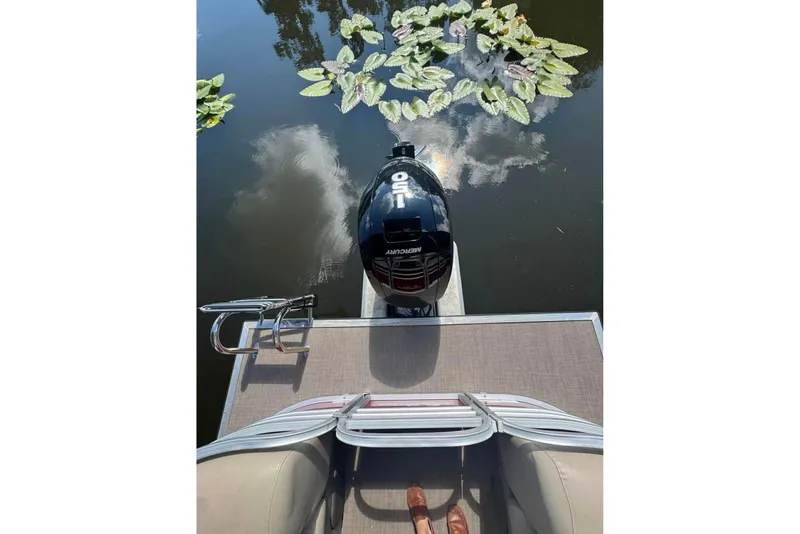 Slide: The Image of 2023 Sun Tracker Party Barge 24 DLX with Mercury outboard motor on calm water. - 8