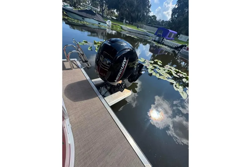 Slide: The Image of 2023 Sun Tracker Party Barge 24 DLX with Mercury outboard motor on a calm lake. - 9