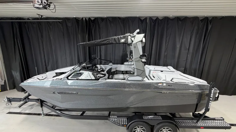Slide: The Image of A gray motorboat is on a trailer inside a garage. - 1